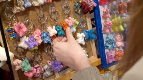 a customer is looking at colorful yarn keychains