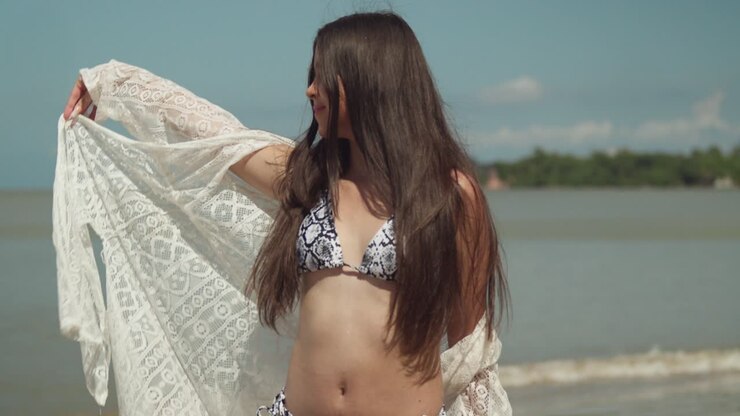 Primo piano di una ragazza latina che si gode una giornata in spiaggia in una giornata di sole.
