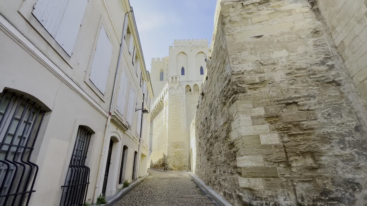 Piccolo e bellissimo vicolo in Francia, formato da vecchie case in pietra chiara e una fortezza sullo sfondo costruita con pietre storiche