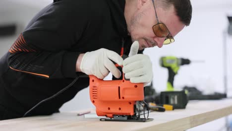 man using a jigsaw to cut wood