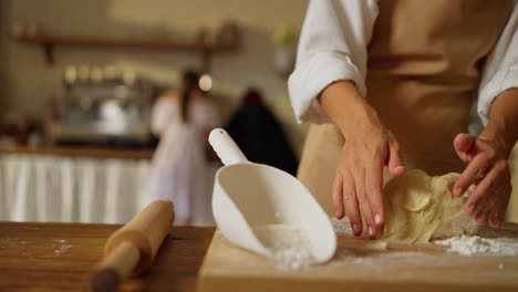 a woman kneads dough in a kitchen