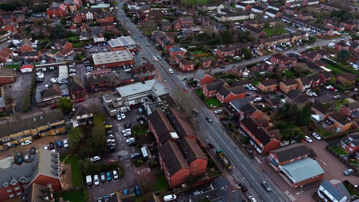 Landscape drone footage panning over the Locks Heath area in Hampshire, South England. A small village near Southampton with a beautiful golden sunset overhead and small suburban houses below