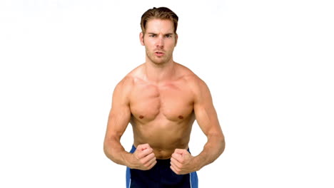 hombre serio sin camisa flexionando los músculos
