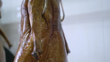 Crispy-Roasted-Duck-Hanging-Inside-The-Kitchen-Of-A-Chinese-Restaurant-In-Guangzhou,-China---tilt-up-shot