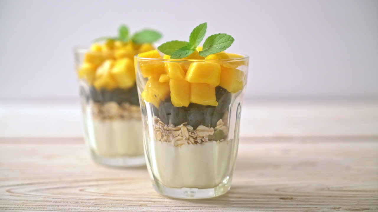 mango fresco casero y arándanos frescos con yogur y granola - estilo de comida saludable