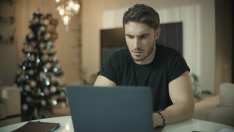 frustrated man working on laptop computer at home. annoyed guy have trouble