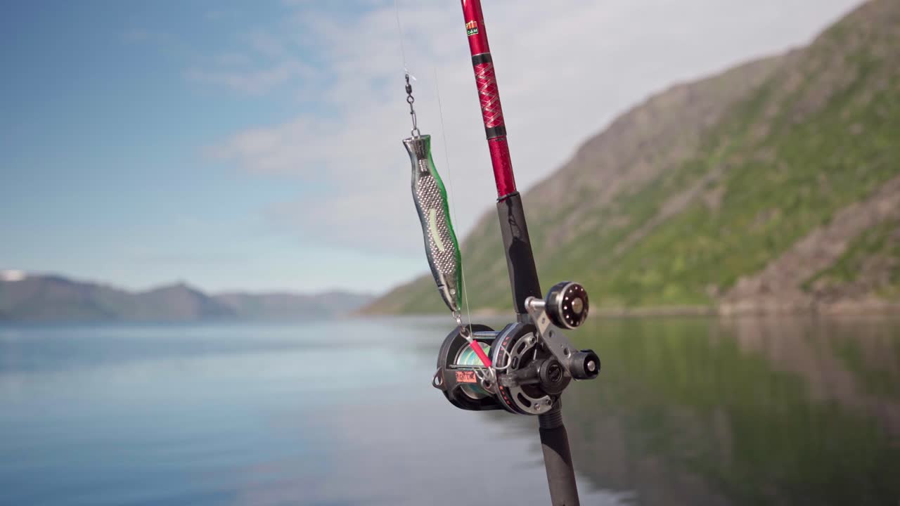 Fiskeudstyr med spinnestang og blink med en lys dag som baggrund i Norge - nærbillede
