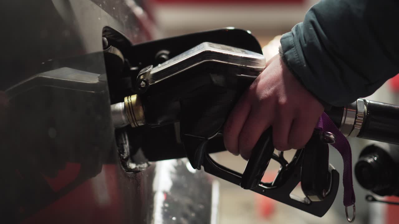 Hand closing car fuel tank door on petrol station, side closeup view