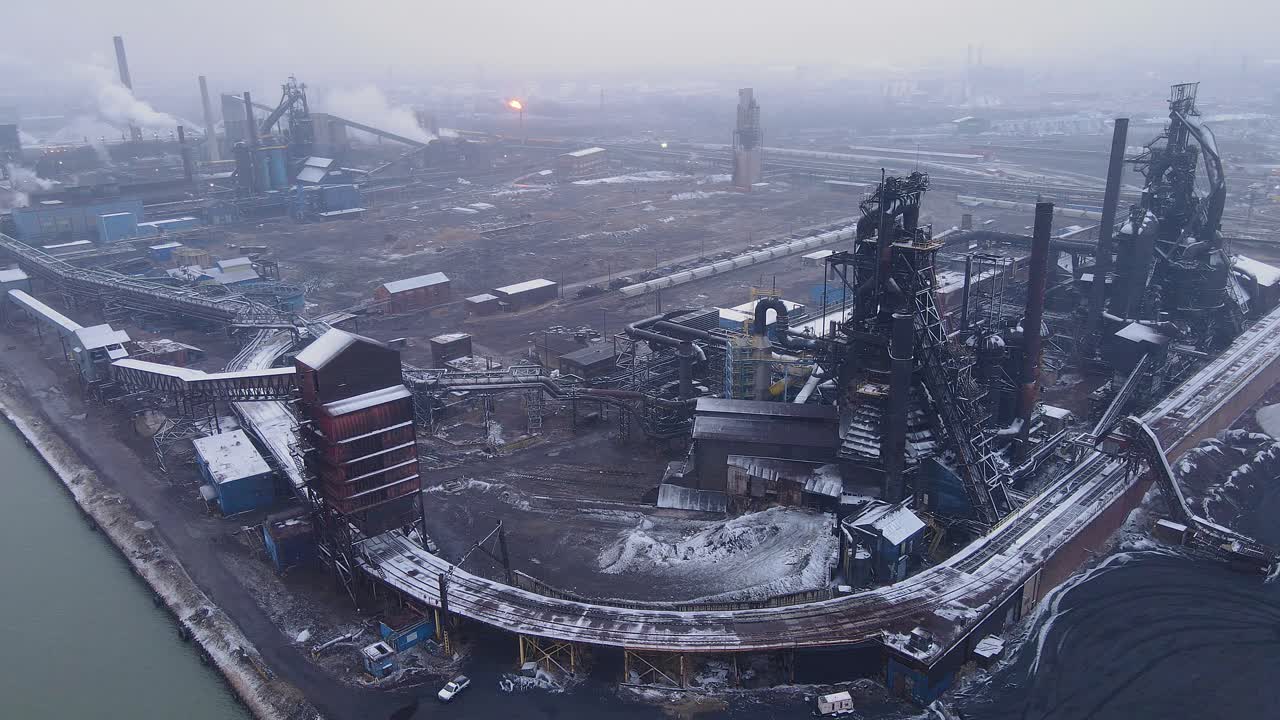 Snow-covered steel plant in Zug Island, River Rouge chimneys and industrial equipment near Detroit