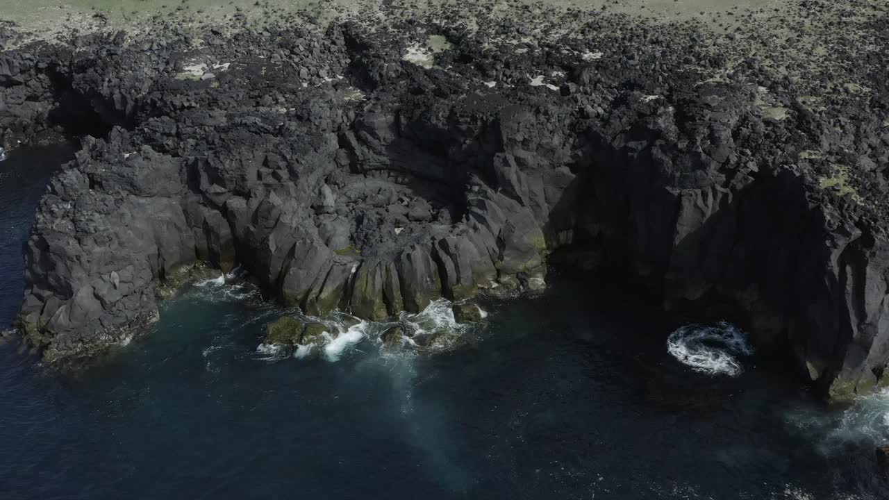 acantilados de basalto volcánico oscuro en la costa de skardsvik en islandia, entorno accidentado