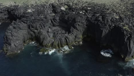 Dark-volcanic-basalt-cliffs-on-Skardsvik-coast-in-Iceland,-rugged-environment