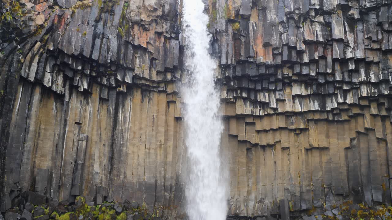 close-up de cámara lenta de agua cayendo sobre la cascada de svartifoss en colores de otoño