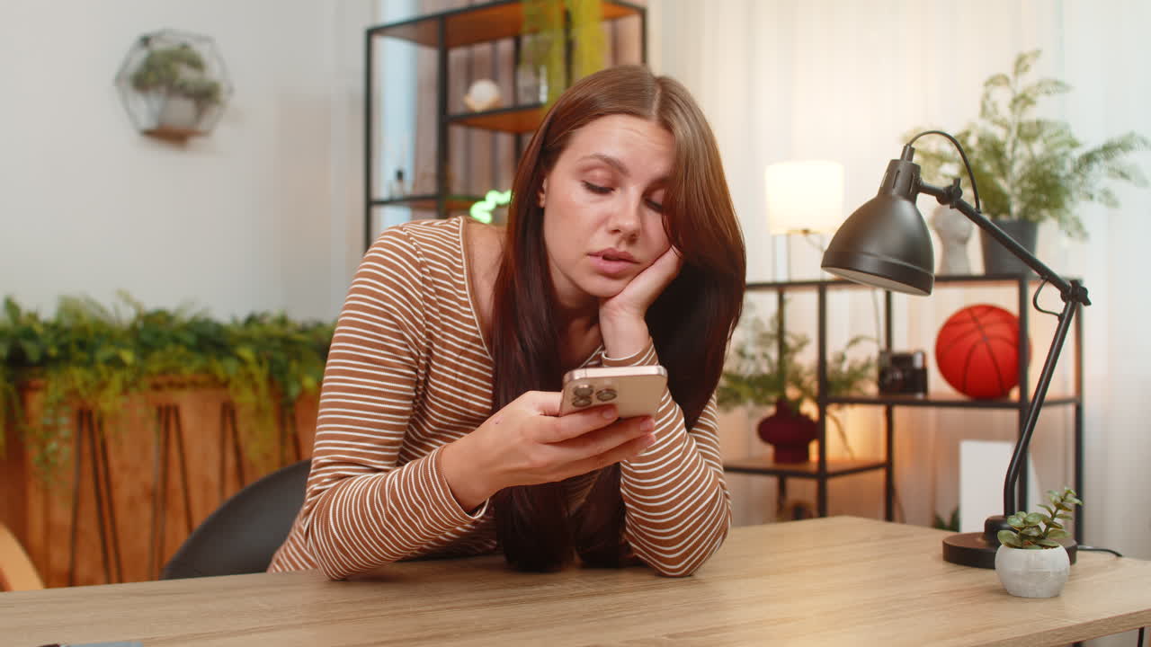 Jovem rola a tela do smartphone com notícias entediada, infeliz e esgotada por posts repetitivos e sem graça nas redes sociais