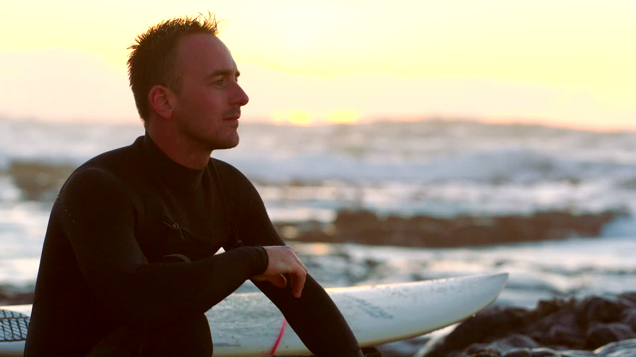 Man surfing on the beach at sunset