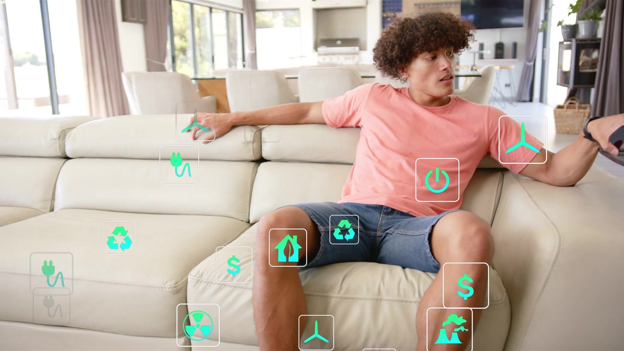 Man tapping smartphone on sofa checking energy finance info with green icons floating around torso