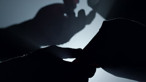 silhouette couple hands holding in dark. man woman arms touching each other