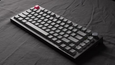 grey mechanical keyboard laid on black fabric background with moving light beam