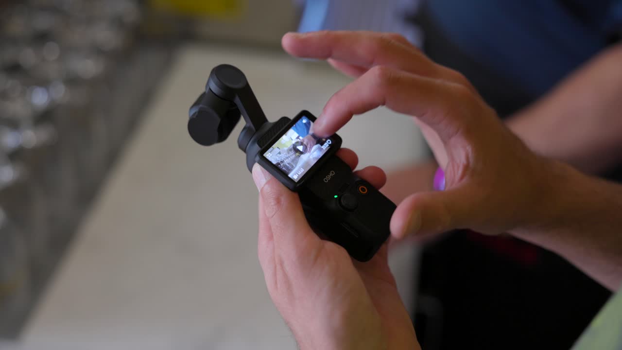 persona borrando el clip de la cámara de bolsillo dji osmo