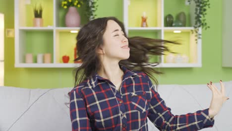 행복한 아름다운 아시아 젊은 여성이 집에서 그녀의 긴 머리카락을  ⁇ 새를 맡고 있습니다.