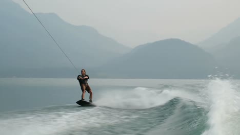 Vorderansicht-Eines-Kaukasischen-Jungen-Mannes,-Der-Tricks-Auf-Dem-Wakeboard-Im-Stadtfluss-Macht,-4k