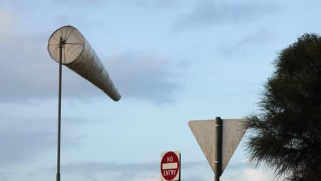 windsock swaying near traffic signs