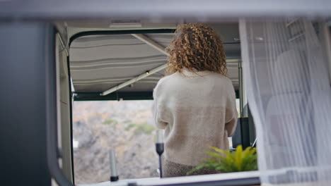 carefree tourist enjoy motorhome weekend standing at kitchen. woman relaxing van