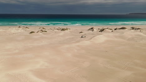 isolated 4wd jeep facing the ocean before a thunderstorm