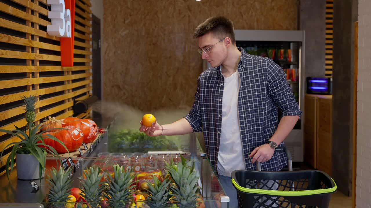 hombre comprando frutas en una moderna tienda de comestibles