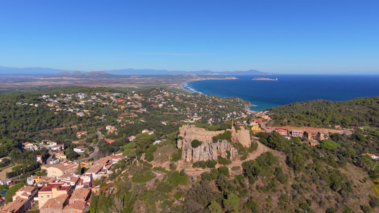 Stunning aerial footage revealing the historic town of begur, its medieval castle ruins, and the beautiful mediterranean coastline of the costa brava, catalonia, on a bright sunny day