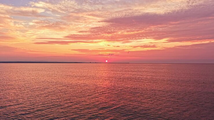 Sunset over the ocean with colorful clouds in the sky at a coastal location during the evening