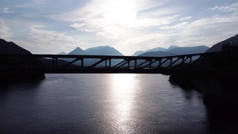 cars driving over ballachulish bridge at loch leven near glencoe on the west coast of scotland with morning sun, aerial drone 4k hd footage fly left