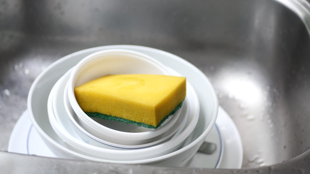 Cleaning cooking pan with a sponge ,