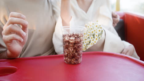 una pareja joven comiendo palomitas de maíz en una rueda de la ferris