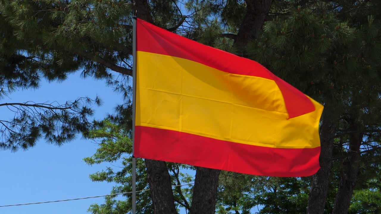bandera de españa ondeando en el viento en cámara lenta cerca con el fondo del cielo