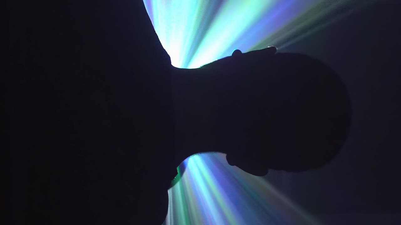 스트리밍 빛으로 최면에 걸린 남자의 실루엣 - 디지털 중독