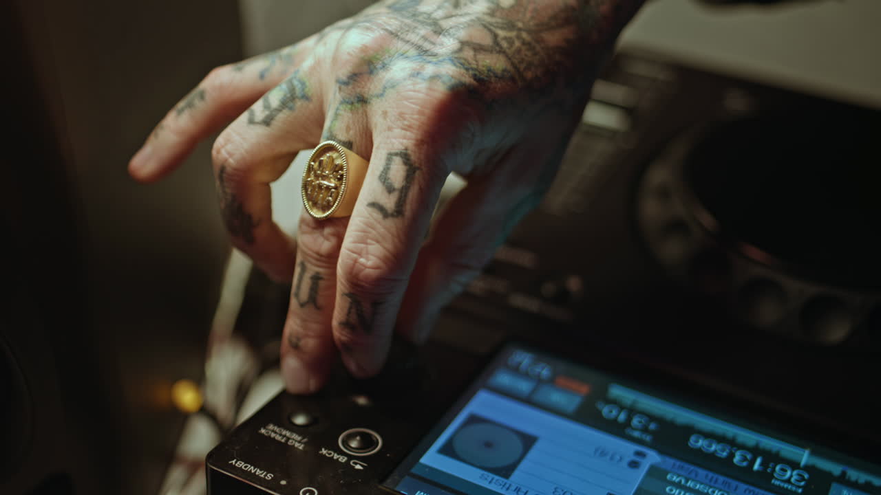 Closeup disc jockey hand with ring on detailed music controller. Dj tattooed