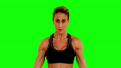 una mujer súper en forma flexionando sus brazos.