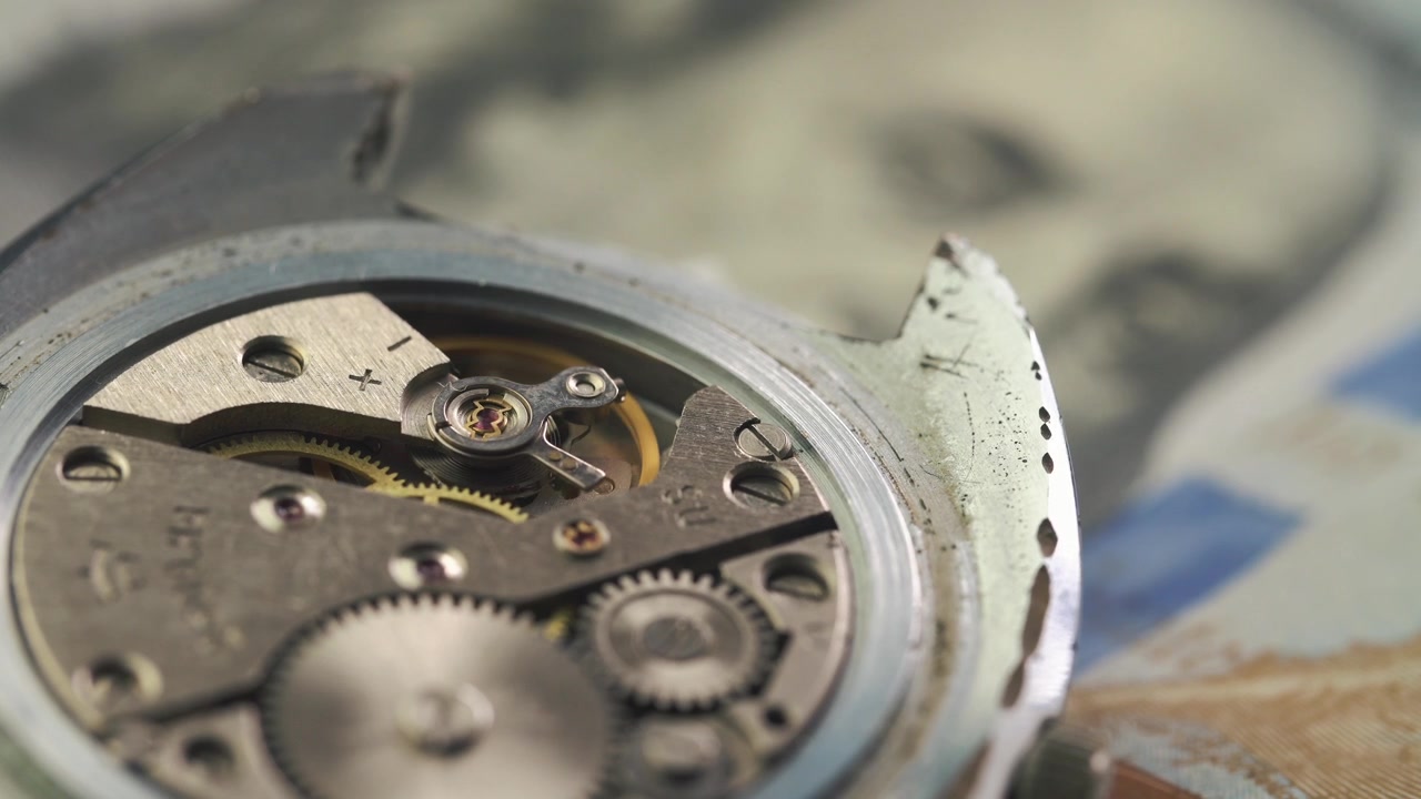 Close-up of a Working Mechanical Watch Movement with a Dollar Bill Background