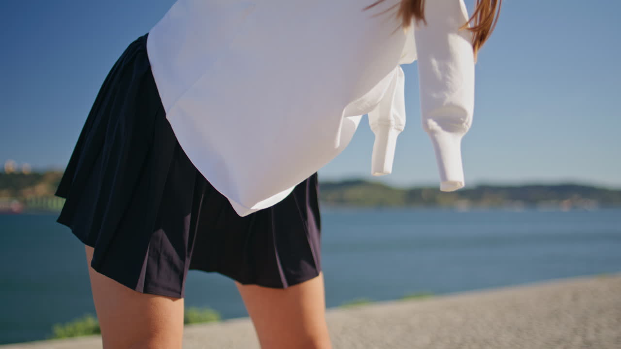Woman bending sporty body at fitness training on waterside closeup. Fit girl