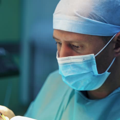 portrait of doctor's face. professional surgeon in medical cap and mask performing a plastic surgery in clinic. close-up.