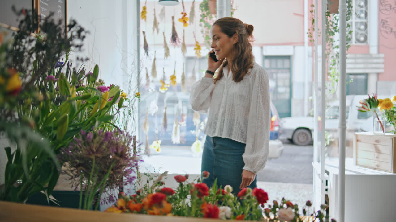 꽃가루 상점 직장에서 꽃 가게 채팅 휴대 전화. 바쁜 여자가 스마트폰으로 이야기합니다.