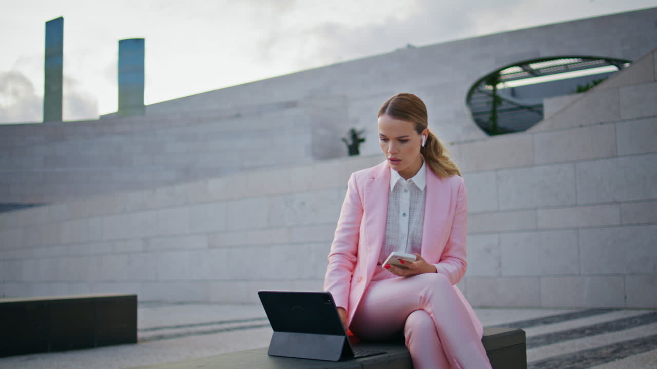 Corporate worker conducting online conference on bench urban area with laptop.