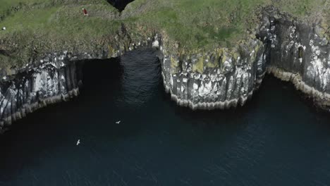 Epic-wild-coast-of-Iceland-with-ancient-natural-stone-bridge-crossing-over-water