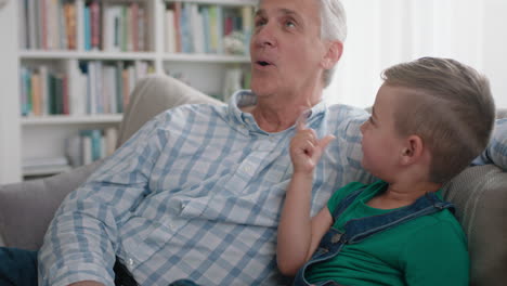 abuelo feliz mostrando al niño pequeño cómo usar el teléfono inteligente enseñando nieto curioso tecnología moderna niño inteligente aprendiendo teléfono móvil sentado con el abuelo en el sofá