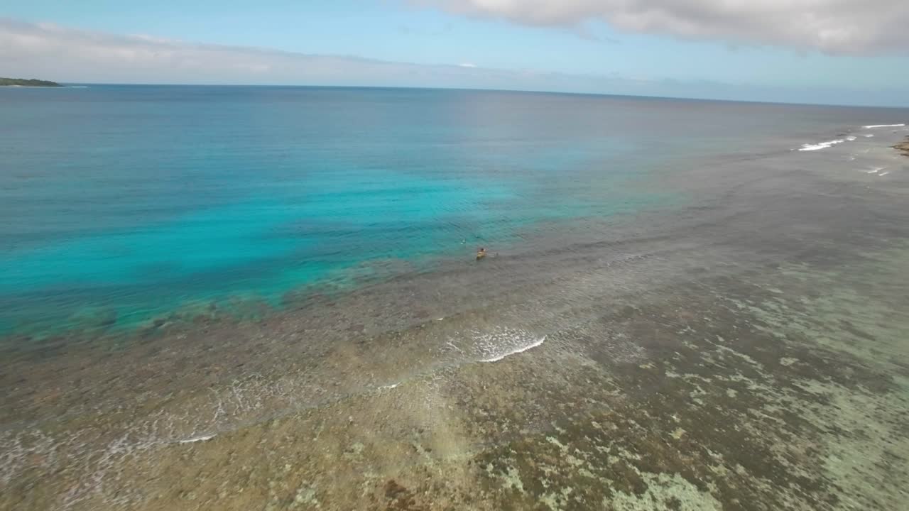 antena cinematográfica de un barco de pesca tradicional que revela la majestuosa y colorida playa de una isla tropical