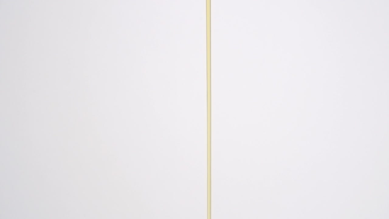 corriente de jarabe de arce de desayuno marrón pegajoso lloviznando sobre fondo blanco en cámara lenta