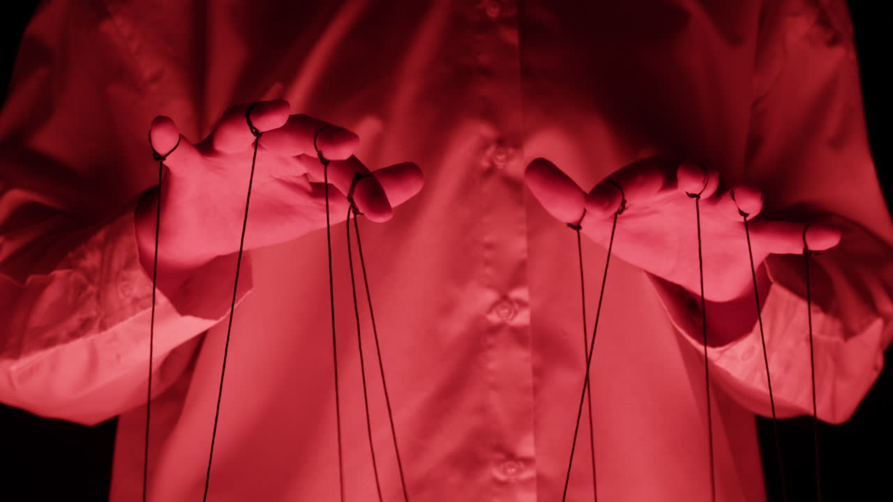 Puppeteer's Hands Manipulating Strings Under Red Light