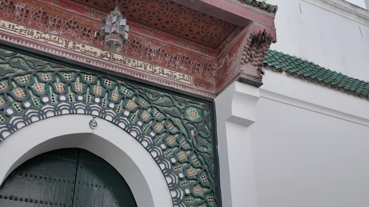Detailed establishing pan of an ornate Moroccan doorway at the Grand Mosque in Tangier, intricate tilework to tower