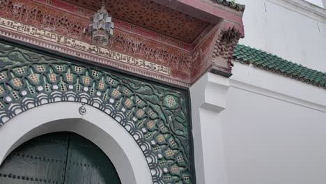 detailed establishing pan of an ornate moroccan doorway at the grand mosque in tangier, intricate tilework to tower