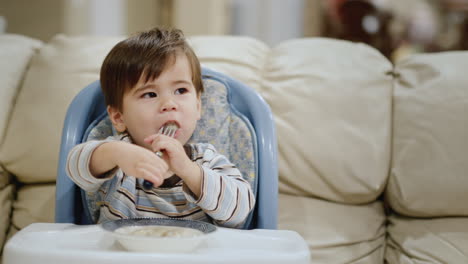 asian kid with appetite eats small dumplings from his bowl